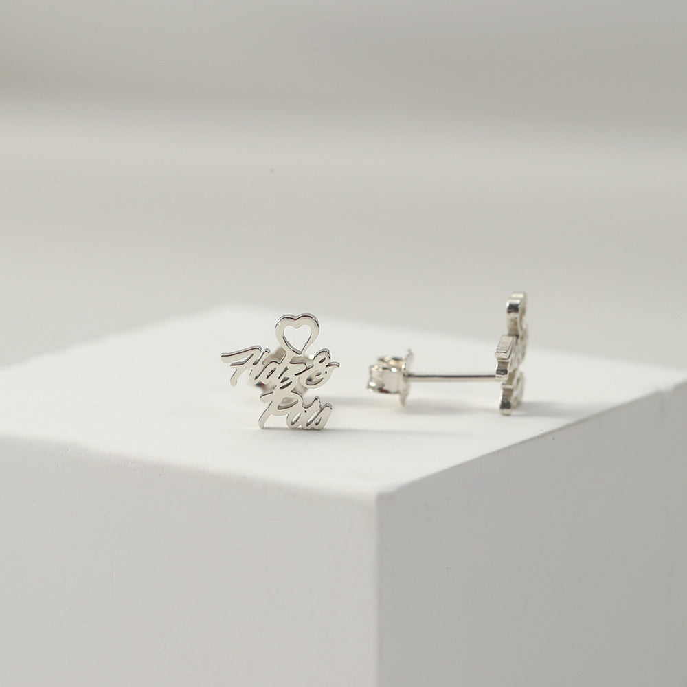 A pair of silver heart-shaped earrings with customisable name design displayed on a white platform.