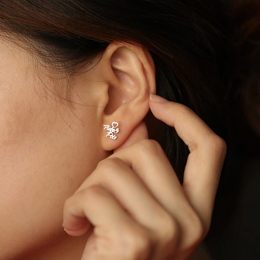 A pair of silver heart-shaped earrings with customisable name design