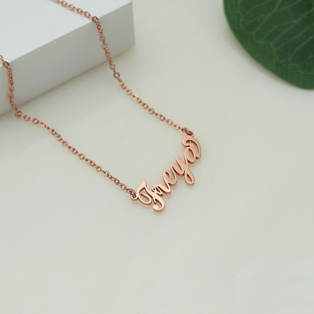A rose gold-coloured name necklace with the name 'Freya' written in cursive script on a white surface.