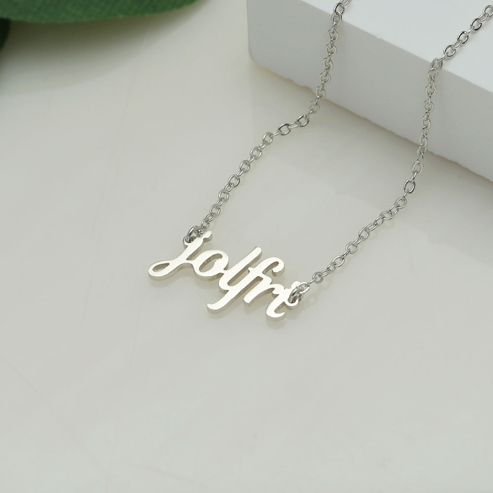 A silver-coloured name necklace with the name 'Jolfre' written in cursive script on a white surface.