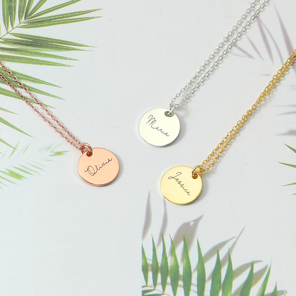Three disc necklace pendants in rose gold, silver, and gold colours, displayed on a white background with palm leaves in the background.