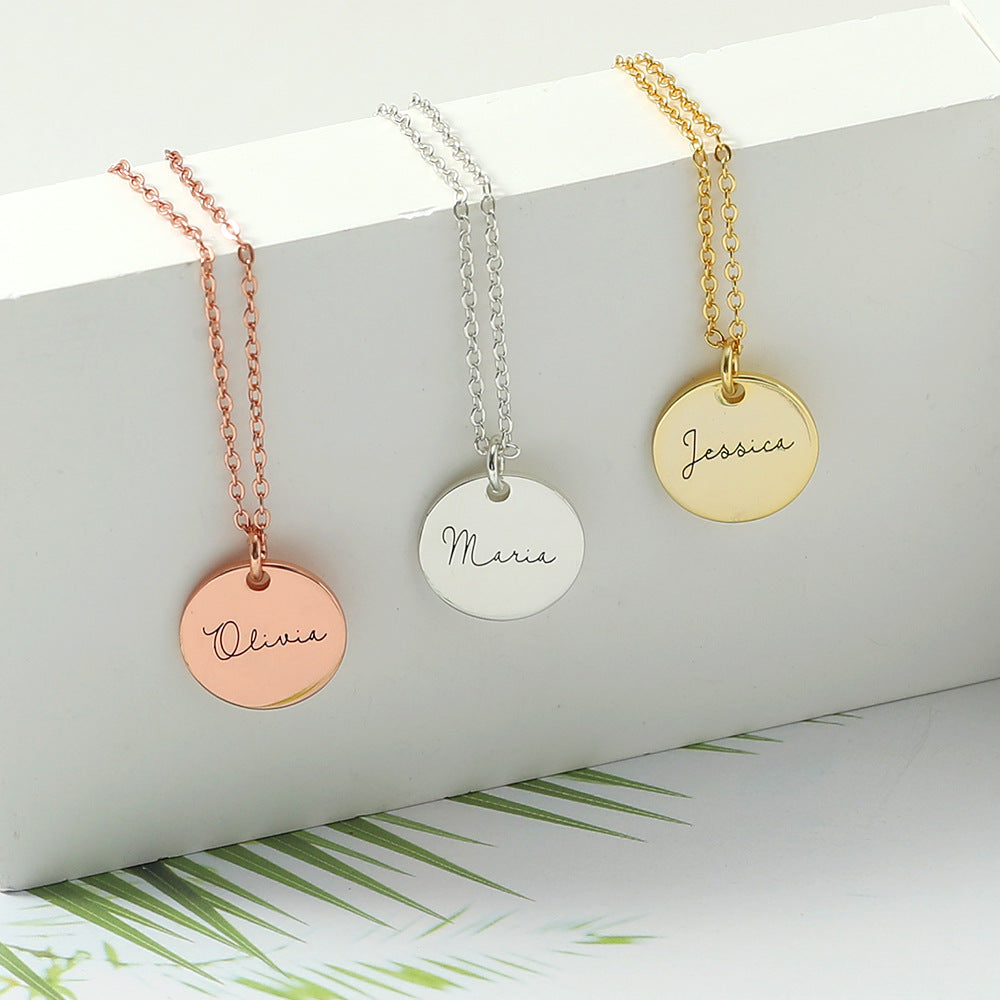 Three disc necklace pendants in rose gold, silver, and gold colours, displayed on a white background with palm leaves in the background.