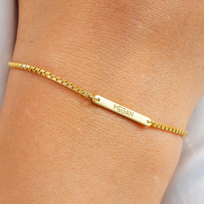 Gold bracelet with 'Megan' engraving on a wrist