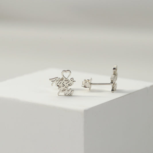 A pair of silver heart-shaped earrings with customisable name design displayed on a white platform.