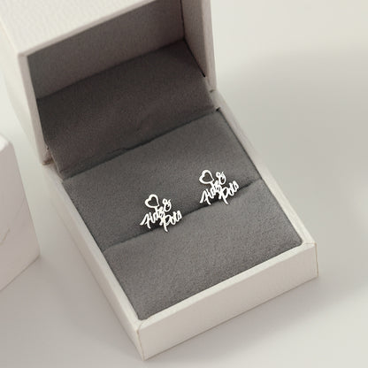 A pair of silver heart-shaped earrings with customisable name design displayed in a white and grey box.