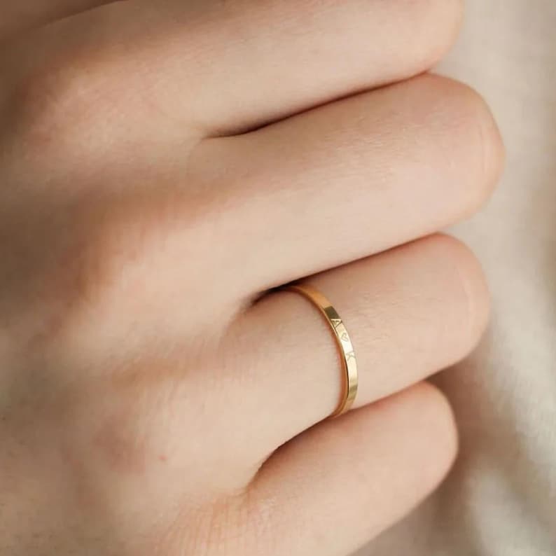 Gold ring on a person's finger with a blurred background