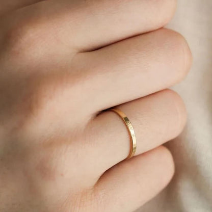 Gold ring on a person's finger with a blurred background