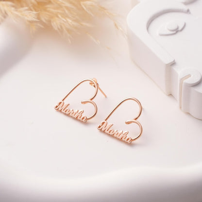 Rose gold earrings with 'Martha' engraved on a light background