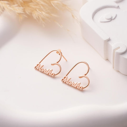 Rose gold earrings with 'Martha' engraved on a light background