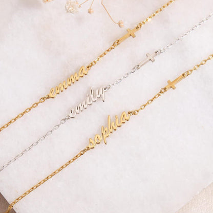 Three gold name bracelets on a white surface