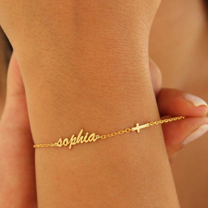 Gold bracelet with 'sophia' on a wrist against a neutral background