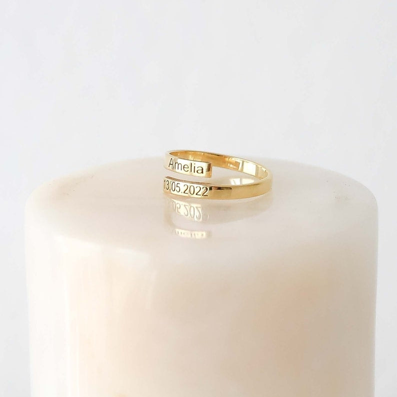 Gold ring with engraved text on a white candle