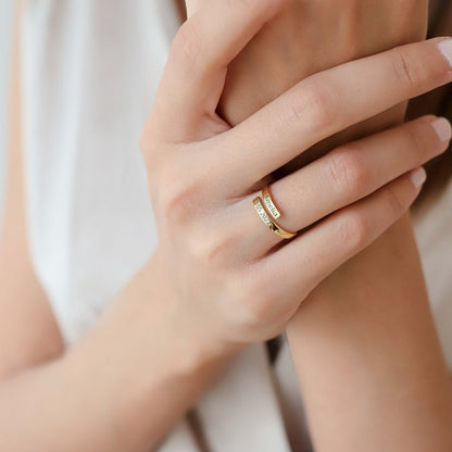 Close-up of a hand wearing a gold ring with a soft background