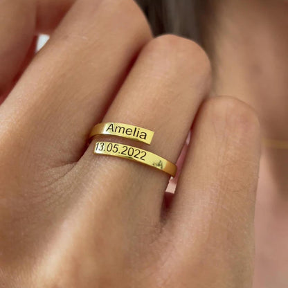 Gold ring with 'Amelia' and a date on a person's finger