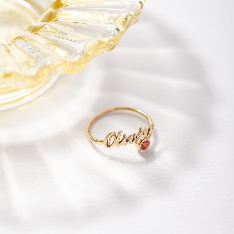Gold ring with 'Olivia' engraving on a white background