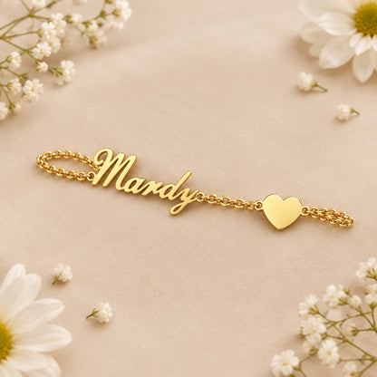 Gold bracelet with 'Mandy' on a beige background with white flowers