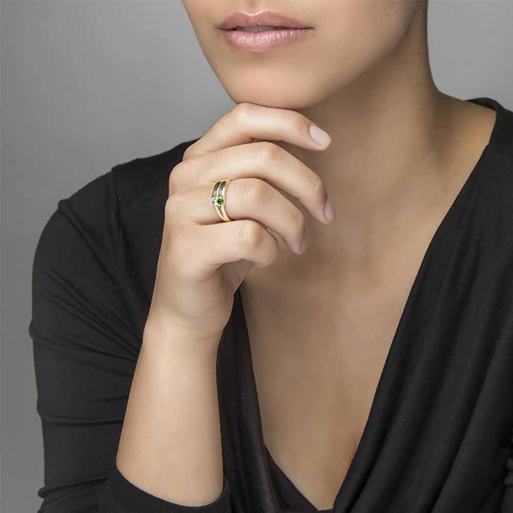 A gold-coloured silver ring featuring two engraved names and two gemstones.