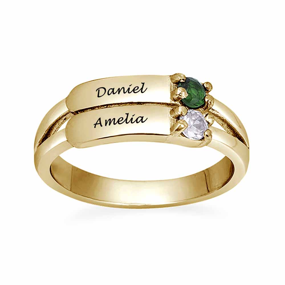 A gold-coloured silver ring featuring two engraved names and two gemstones.